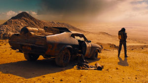 Mad Max with car. © Warner Bros. Pictures